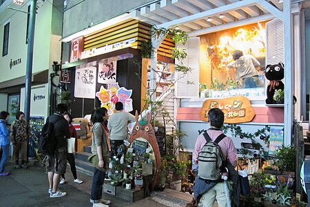 Vetrine di un negozio dello Studio Ghibli in Giappone con persone che osservano l'esposizione esterna.