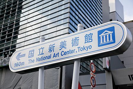 Cartello per il National Art Center a Tokyo con edifici moderni.