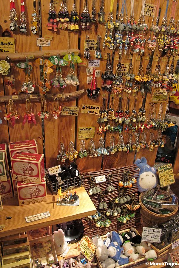 Parete in legno di un negozio dello Studio Ghibli in Giappone ricca di portachiavi e gadget dei personaggi animati.