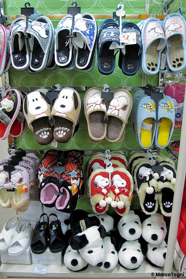 Scaffali di un negozio Kiddyland ad Harajuku con una vasta selezione di pantofole di Snoopy in vari stili e colori.