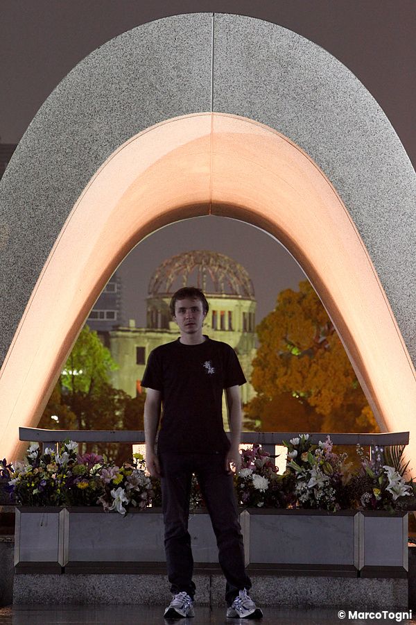 Marco Togni in piedi davanti al Cenotafio per le vittime della bomba atomica ad Hiroshima con la cupola sullo sfondo.