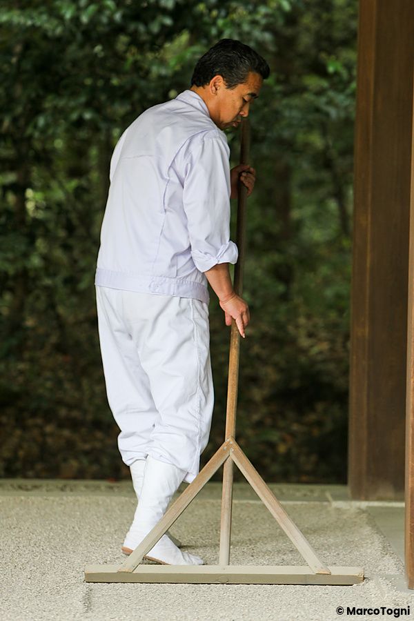Persona che rastrella il terreno vicino al tempio Meiji Jingu in Giappone.