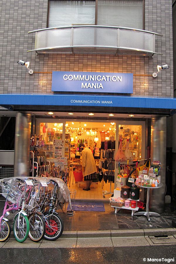 Negozio luminoso con biciclette coperte da teloni a Shimokitazawa