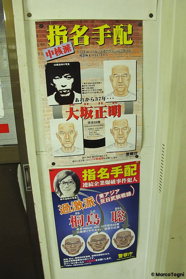 Due manifesti di ricerca persone della polizia giapponese affissi su una parete in un luogo pubblico in Giappone.