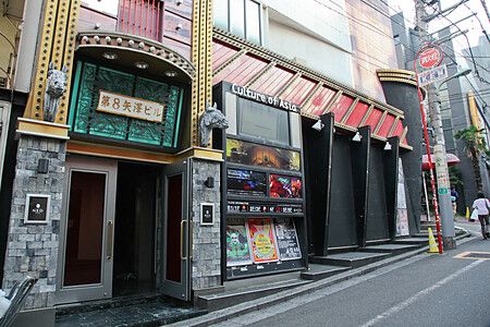 Ingresso di un love hotel in Giappone con insegne luminose su strada cittadina.