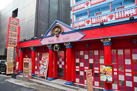 Facciata colorata di un love hotel in Giappone con colonne rosse.