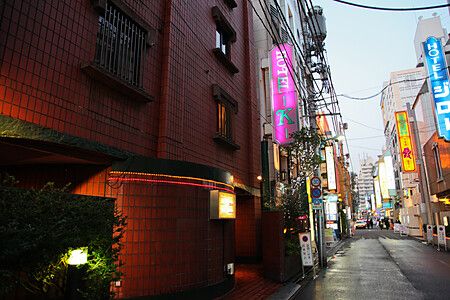 Facciata di un love hotel in Giappone con insegne al neon.