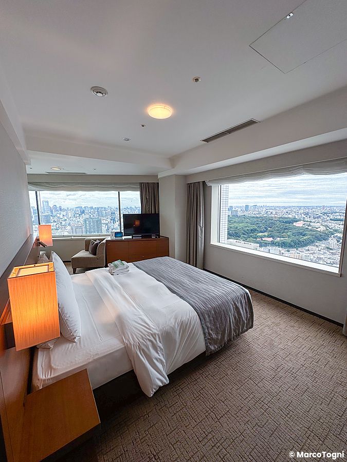 Una camera dell'Hotel Century Southern Tower a Shinjuku con letto matrimoniale e vista panoramica sulla città.
