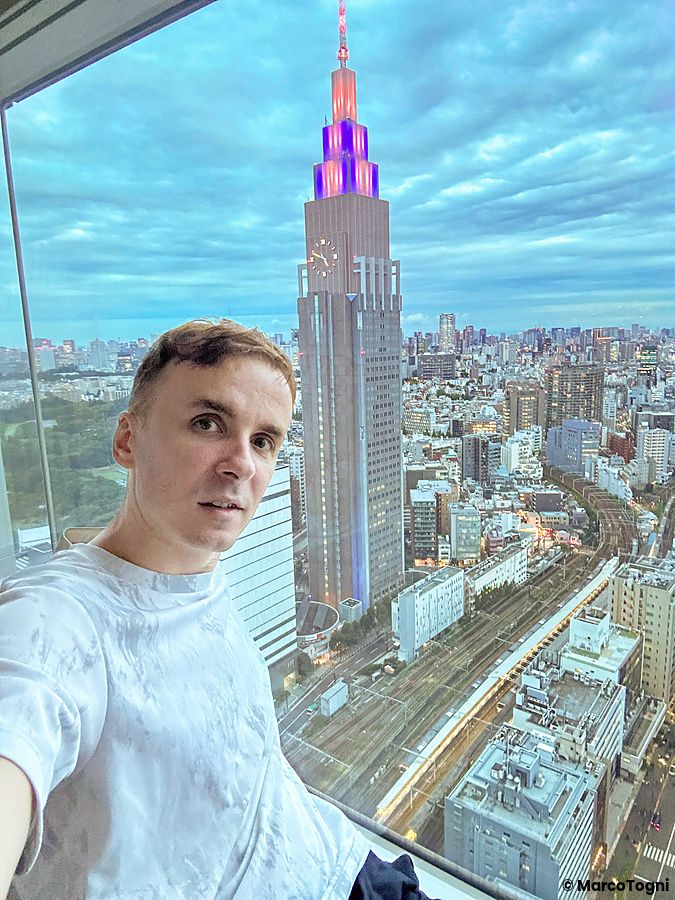 Vista su NTT Docomo Yoyogi Building da una stanza con Marco Togni in primo piano.