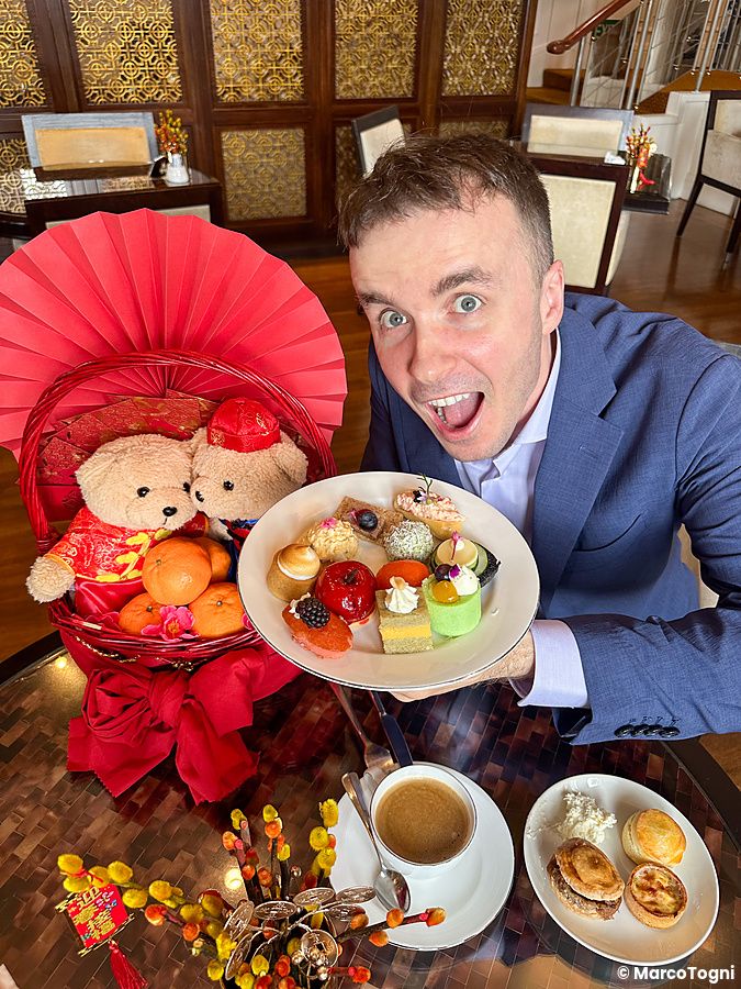 Marco Togni elegante tiene un piatto di dolci nell'executive lounge di The Fullerton Hotel.