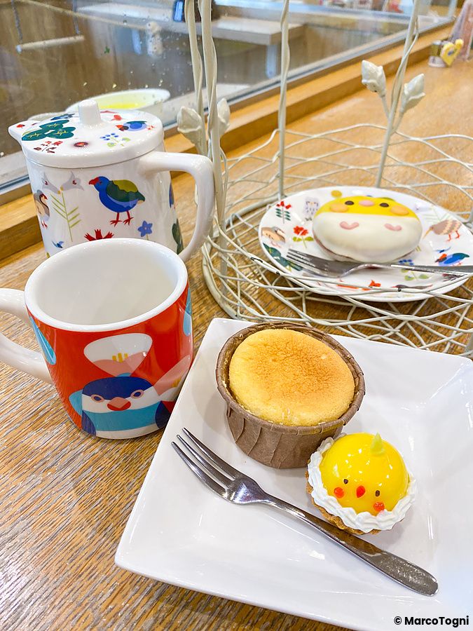 Set di dolci e bevande a tema uccellini serviti su un tavolo di legno all'interno del Kotori Cafe di Osaka.