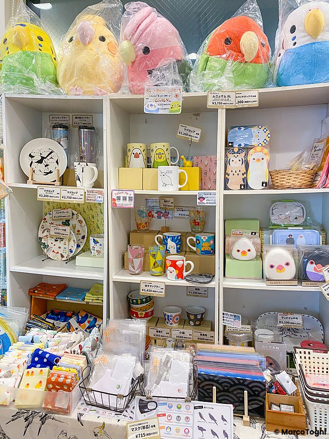 Scaffali del Kotori Cafe ad Osaka pieni di gadget colorati a tema uccellini, inclusi peluche, tazze e piatti.