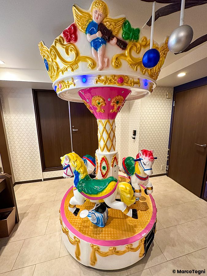 Giostra colorata con cavalli e angelo all'interno di una stanza a tema dolci a Shibuya.