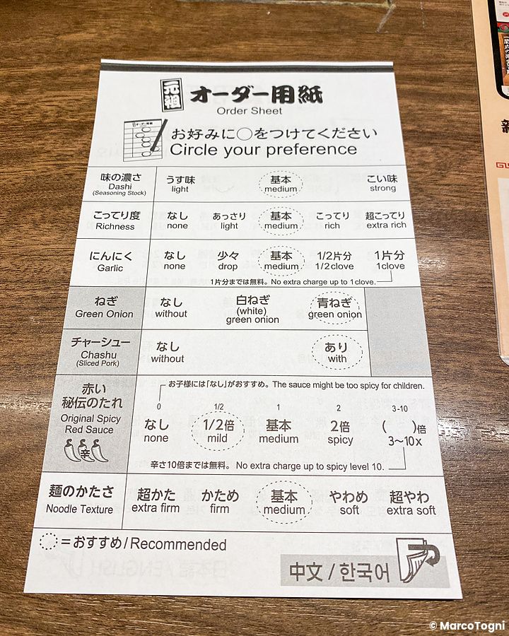 Un modulo per personalizzare il ramen a Ichiran appoggiato su un tavolo di legno in un ristorante giapponese.