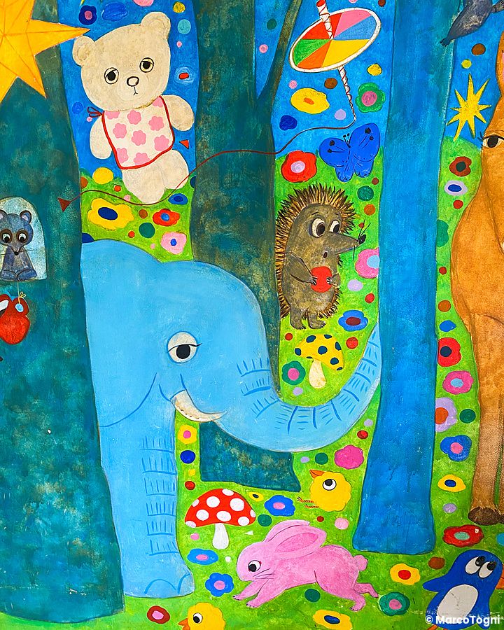 Un murale colorato all'interno del ristorante Hattifnatt a Kichijoji che ritrae animali fantastici in una foresta.