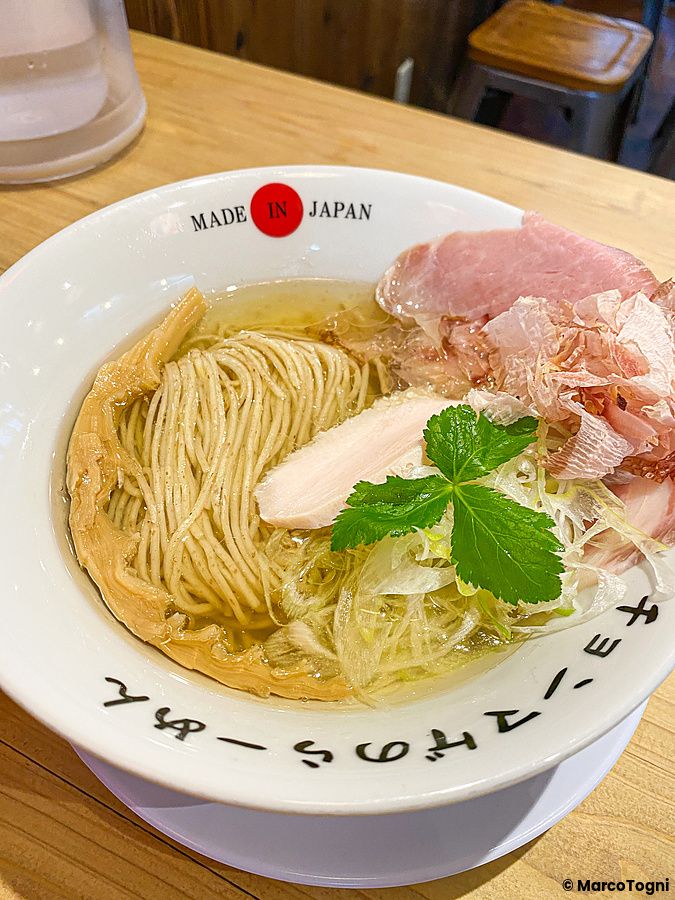 Una ciotola di ramen con brodo chiaro, noodles, carne e katsuobushi servita al Ramen Chonmage Osaka Tenroku Ten a Osaka.