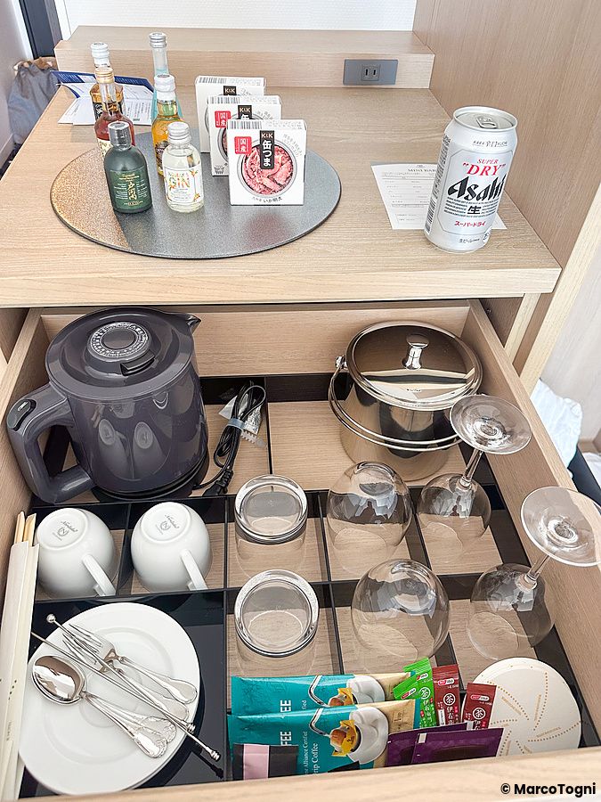 Cassetto e piano superiore del minibar ben organizzati in una stanza del Tokyo Dome Hotel a Tokyo.
