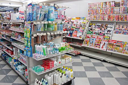 Scaffali di un conbini giapponese con articoli per la cura personale e riviste.