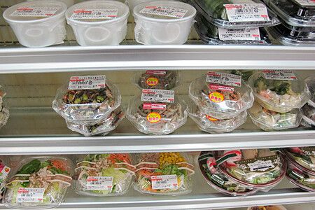 Diverse confezioni di cibo preconfezionato su scaffali in un negozio di alimentari.