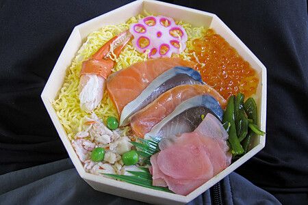 Ekiben giapponese con salmone, uova di pesce, verdure e riso.