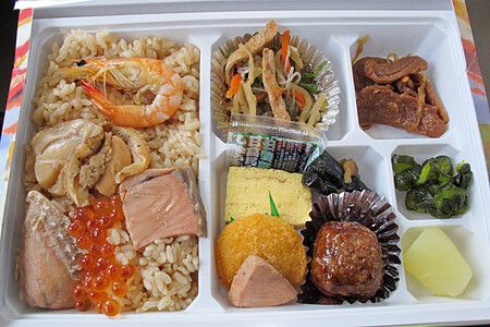 Vassoio di ekiben con riso, gamberi e verdure assortite in Giappone.