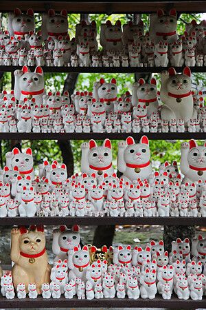 Statuette di maneki neko sugli scaffali al Tempio Gotokuji di Tokyo.