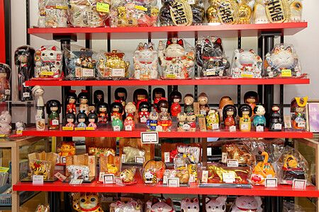 Scaffali con souvenir giapponesi come bambole kokeshi e gatti Maneki Neko.