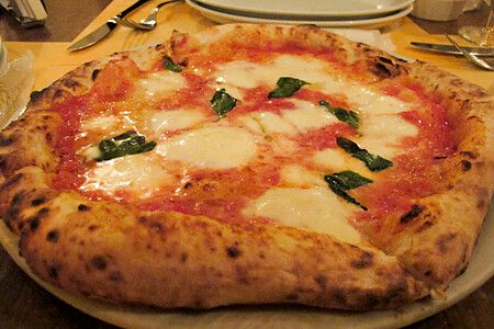 Pizza margherita con mozzarella e basilico su piatto