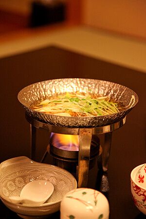 Piatto di cucina kaiseki servito su fornello da tavolo al ryokan Ichinomatsu, Hakodate.