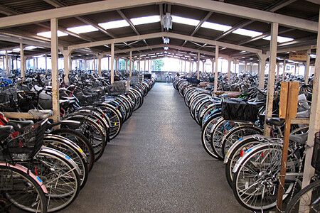Parcheggio per biciclette coperto a Shinden con numerose biciclette allineate.