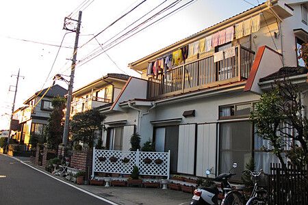 Strada residenziale a shinden con case giapponesi e biciclette.