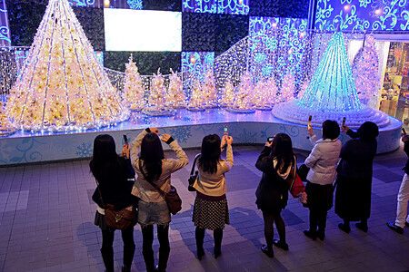 Persone che fotografano le luminarie natalizie a Shinjuku Terrace City.