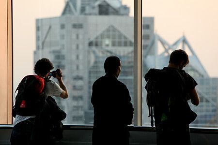 Tre persone guardano il tramonto attraverso una finestra a Tokyo.