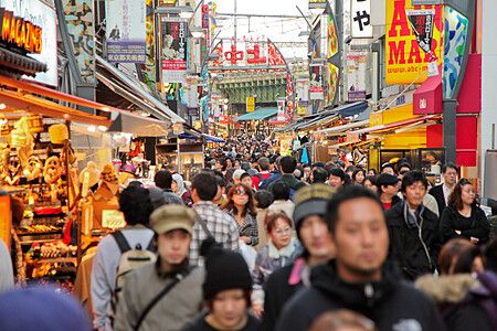 Una folla compatta percorre la via commerciale di Ameyoko a Ueno, Tokyo, fiancheggiata da negozi e insegne colorate.