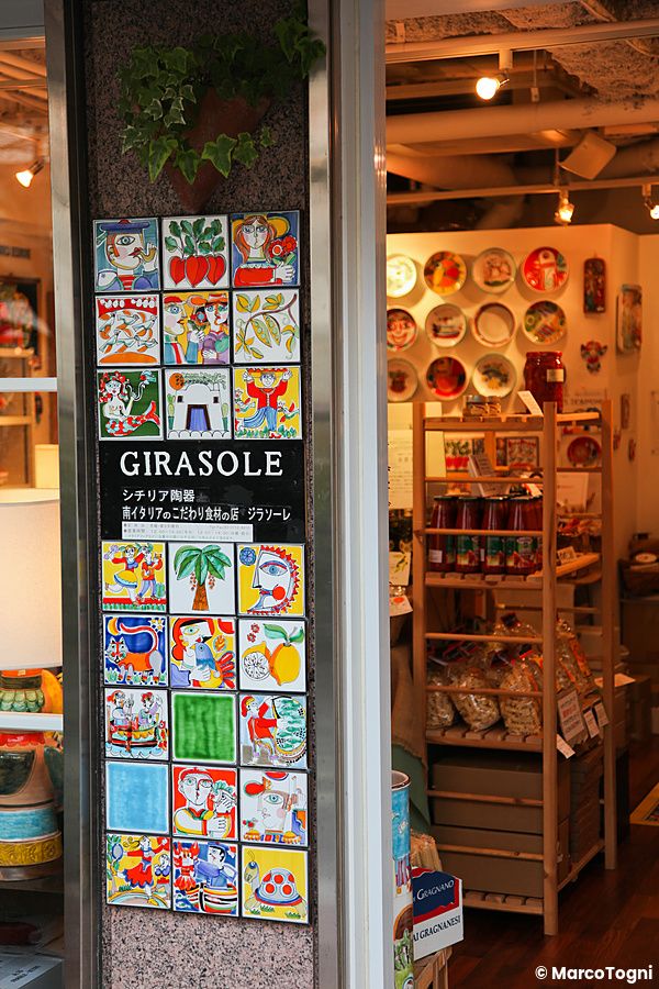 Facciata del negozio girasole giappone in Giappone con colonna decorata da piastrelle illustrate e interno espositivo.