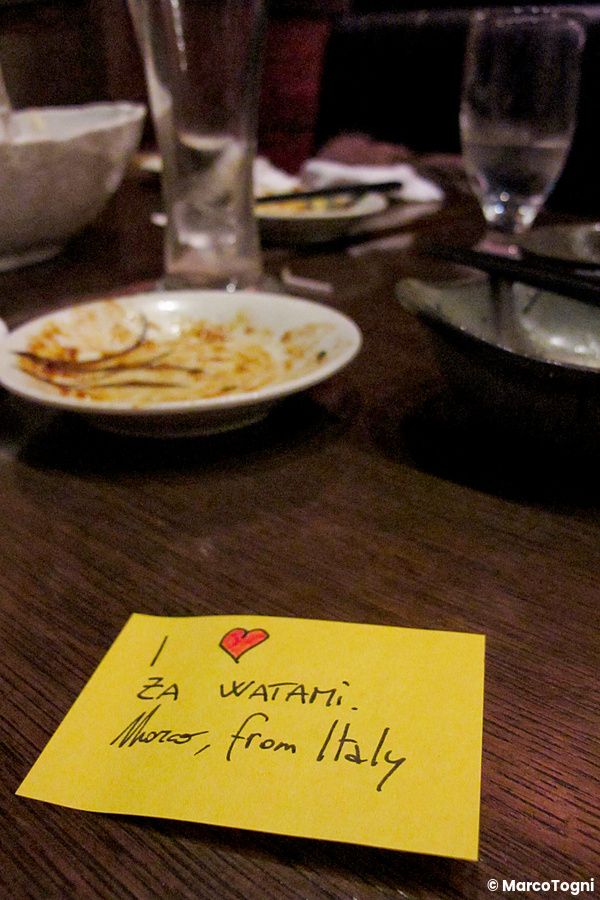 Un foglietto adesivo giallo con scritto "I love Watami" e "Marco, from Italy" su un tavolo di un Izakaya.