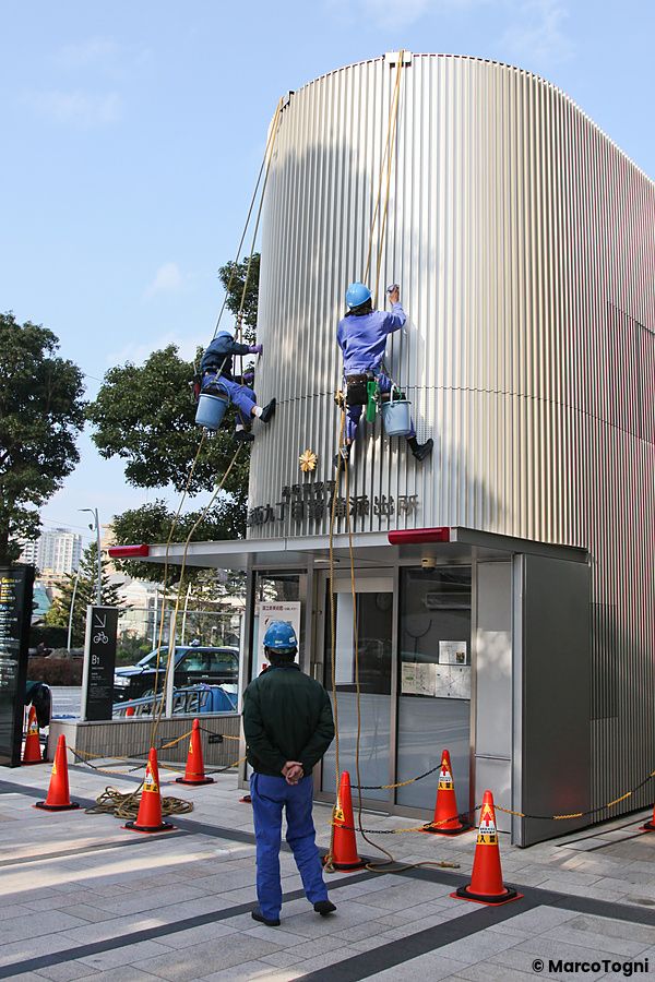 Persone che lavorano su un edificio di koban con coni di sicurezza.