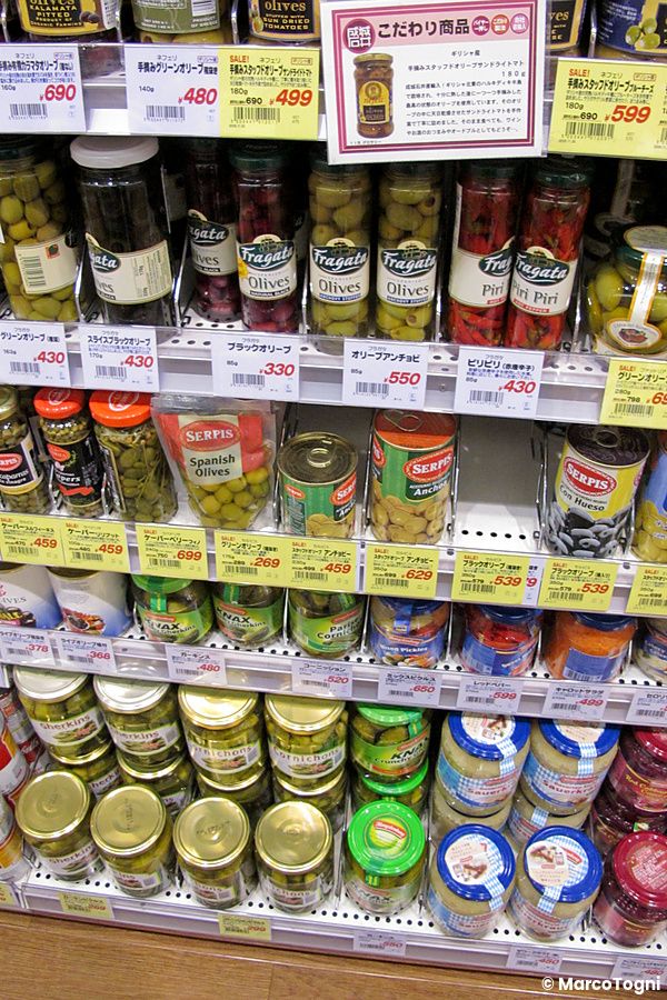 Scaffali pieni di barattoli di olive e sottaceti presso il supermercato Seijo Ishii in Giappone.