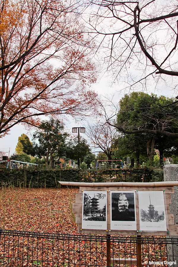 Una bacheca con foto d'epoca si trova nel parco a Yanaka durante la stagione autunnale, circondata da alberi e foglie.
