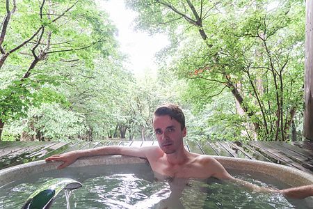 Marco Togni in un bagno sul terrazzo con verde circostante a Oku Nikko Hotel Shikisai.
