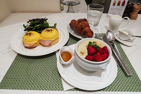 Colazione con uova alla Benedict, yogurt con frutta e croissant servita al tavolo nel ristorante Sarabeth a Tokyo.
