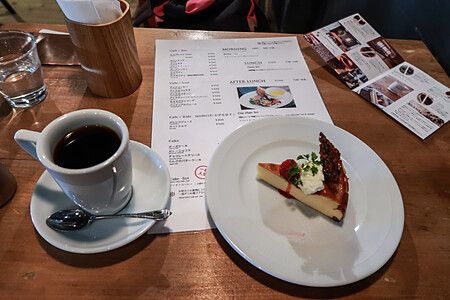 Tazza di caffè e fetta di torta su un tavolo di legno.
