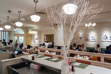 Veduta interna del ristorante Sarabeth a Tokyo con clienti seduti ai tavoli in una sala luminosa.