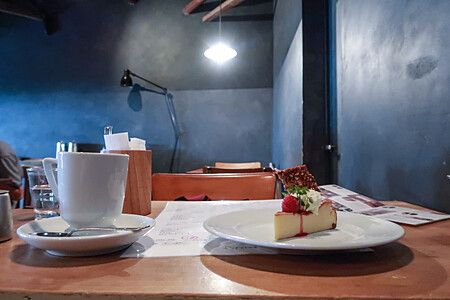 Interno della caffetteria Sarasvati a Miyajima con caffè e torta su un tavolo.