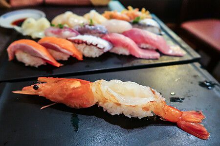 Assortimento di sushi su piatto nero in un ristorante giapponese.