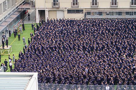 Folla di studenti in divisa in un cortile scolastico in Giappone.