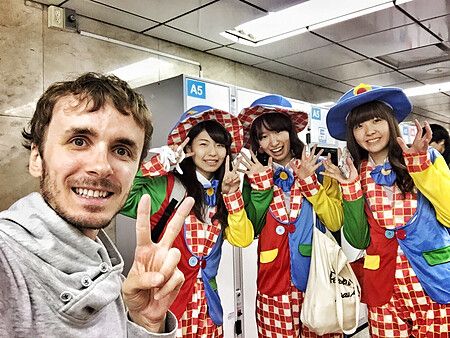 Marco Togni con tre individui in costumi da clown durante Halloween in Giappone.