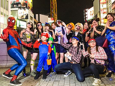 Gruppo di persone in costumi festeggiano halloween in una strada di Osaka.