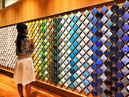 Donna osserva parete di carta colorata a Ginza.