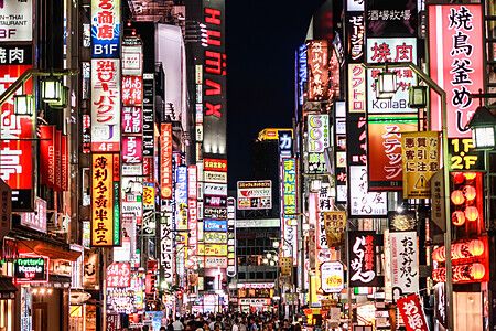 Strada di Kabukicho a Tokyo illuminata da insegne al neon.